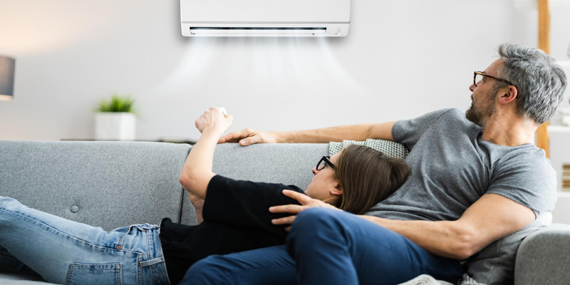 Couple turning on the AC to keep the house cool in extreme heat and beat the summer heat.