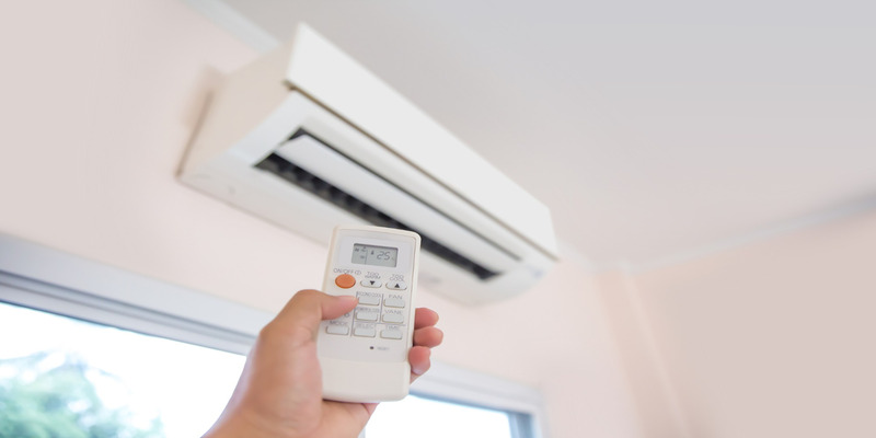 A woman turns on the fan mode on her air conditioner.