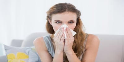 Woman with allergies wiping her nose due to dust irritation