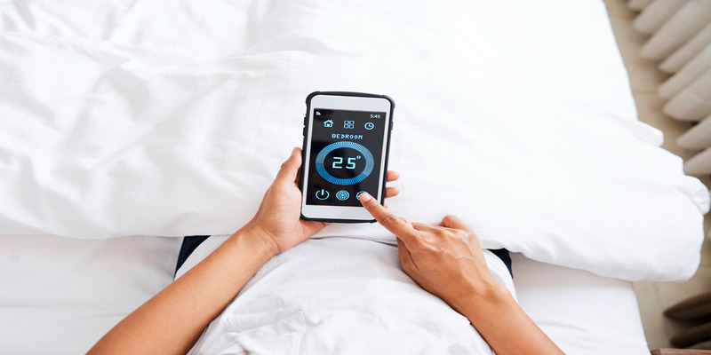 The user adjusts the air conditioner temperature on a smartphone via a mobile application.