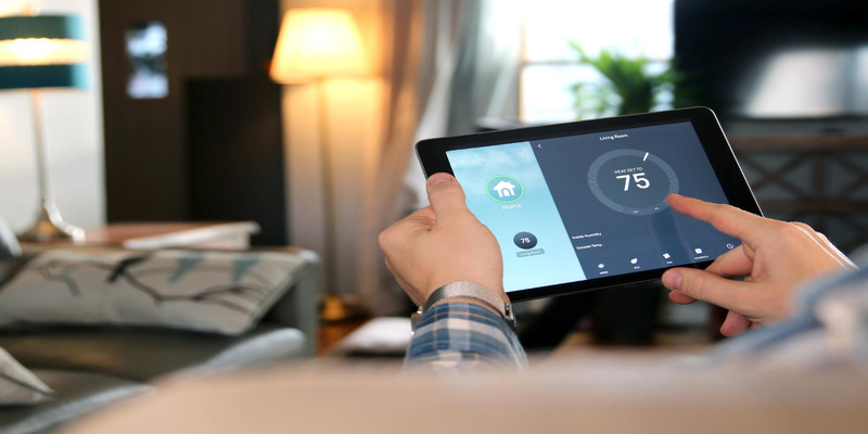 A person is using a tablet to adjust the temperature of their living room through a smart climate control system.