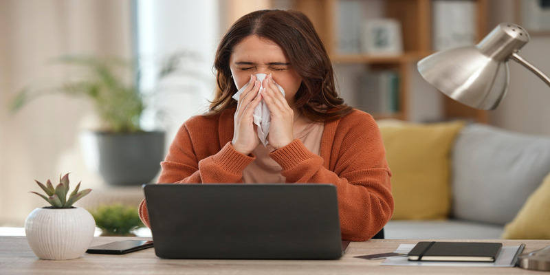 Woman sneezing indoors due to possible AC allergies