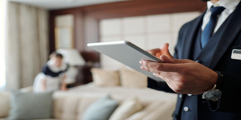 Hotel manager using tablet to monitor room energy use