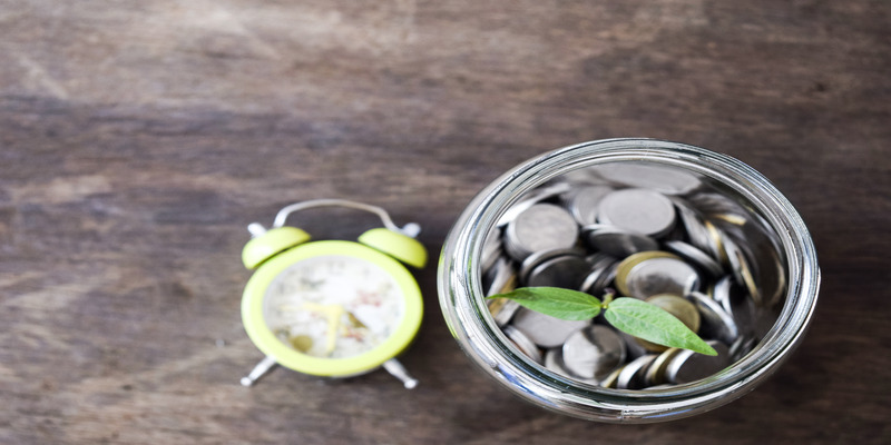 A jar filled with coins symbolizes savings and the financial benefits of using energy-efficient technology, such as Sensibo.