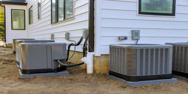Residential HVAC outdoor units beside a house