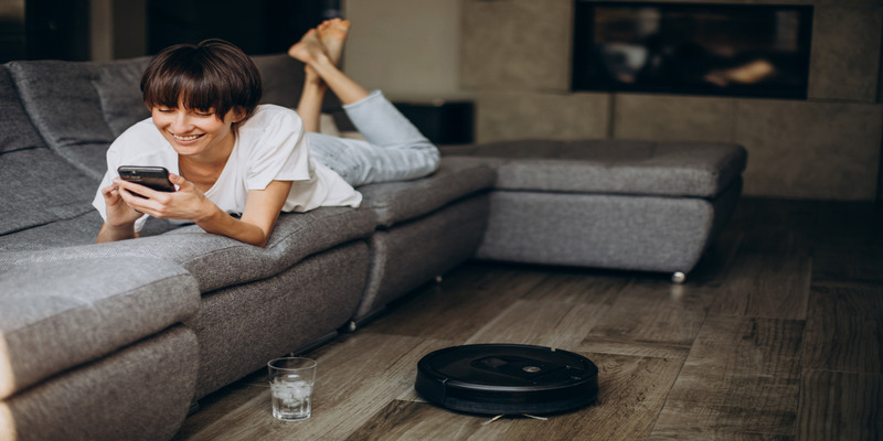 Guest relaxing with robot vacuum cleaning Airbnb living room