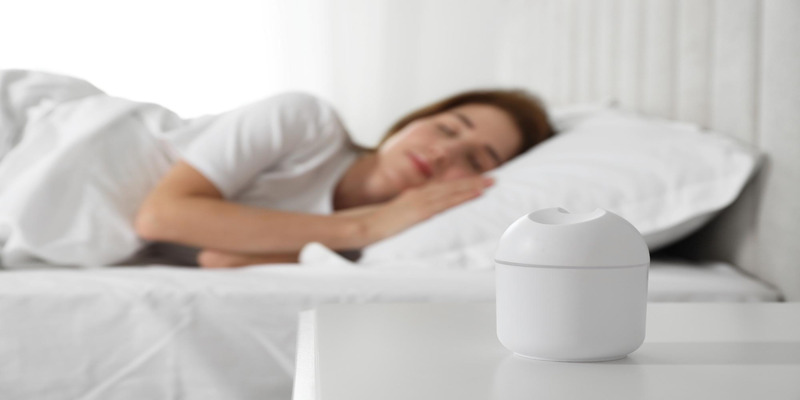 Woman sleeping near bedside air purifier device