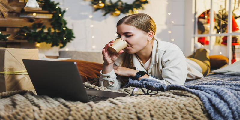 Woman at home using laptop, thermostat energy savings winter